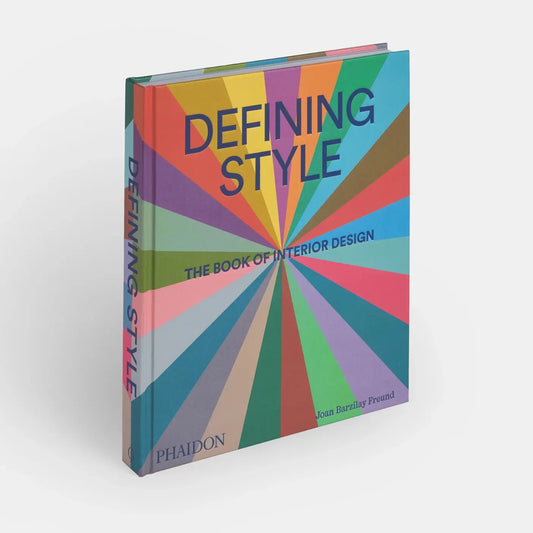 Open interior design book titled "Defining Style" by Phaidon, showcasing stylish interior spaces and design inspiration.