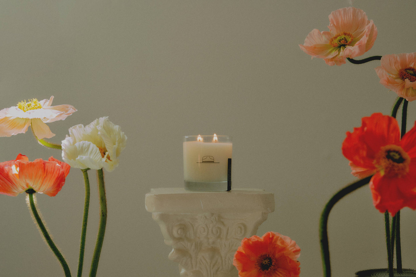 Ozmun Home Superbloom Candle with floral design in a glass jar, showcasing a warm, inviting glow and colorful flower accents.