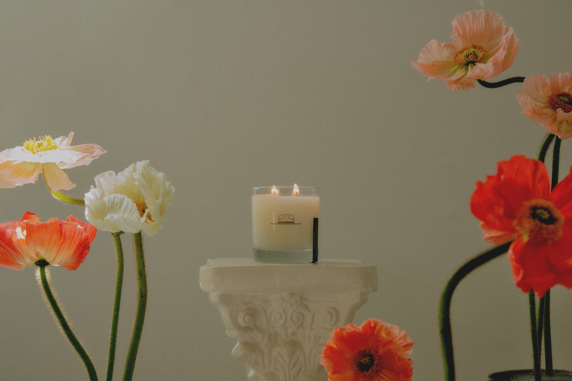 Ozmun Home Superbloom Candle with floral design in a glass jar, showcasing a warm, inviting glow and colorful flower accents.